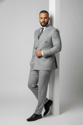 Man in grey double-breasted pinstripe suit with tailored fit and black shoes.